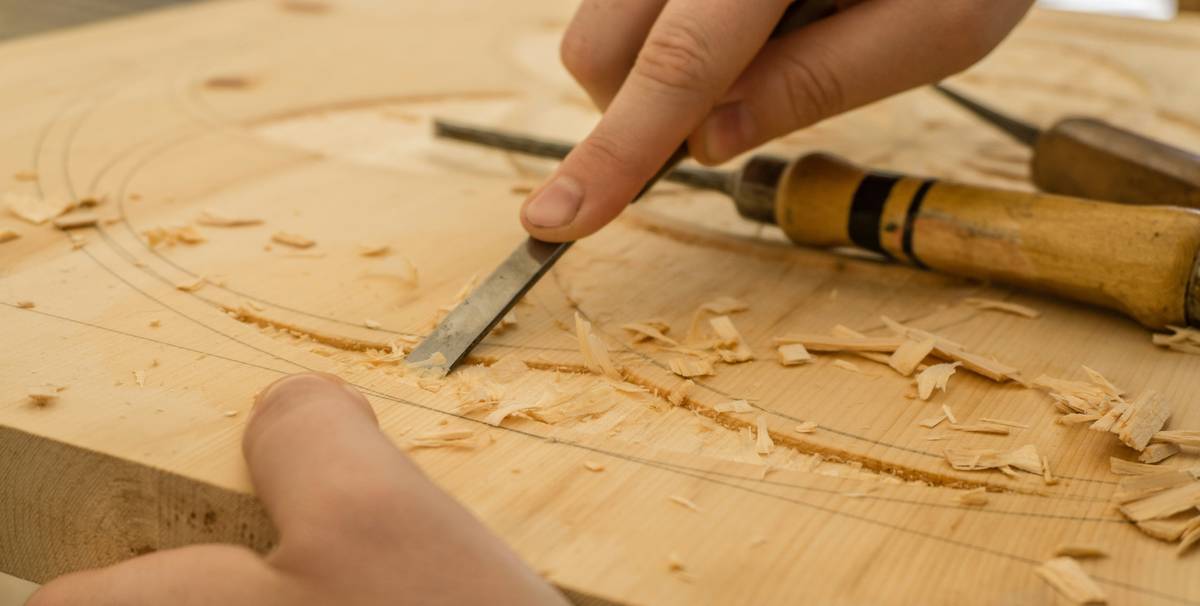 Close-up of replacement hand saw blades lined up on a workbench with measuring tape and wood samples